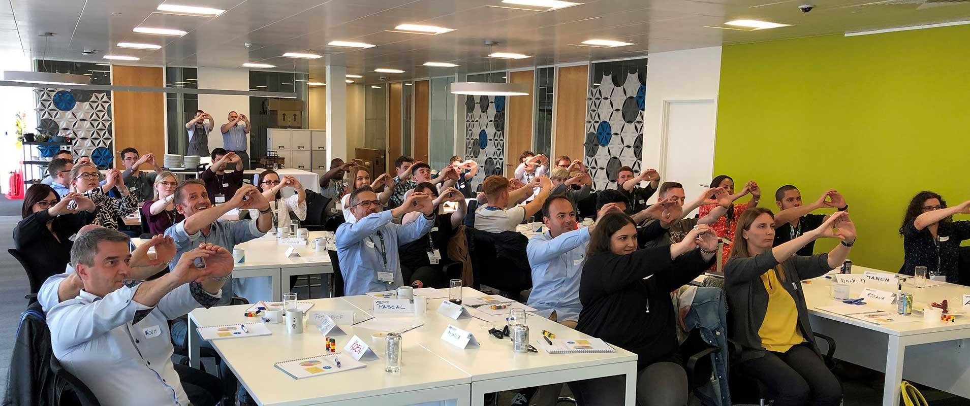 Workshop where participants have arms extended making a circle with hands